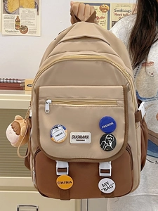 Detail of school backpack showing multi-pocket design and colorful decorative badges