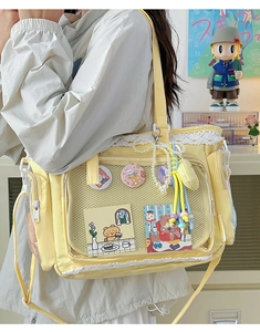 Detail einer hellgelben Canvas-Itabag mit Sichtfenster für niedliche Charakter-Anstecknadeln