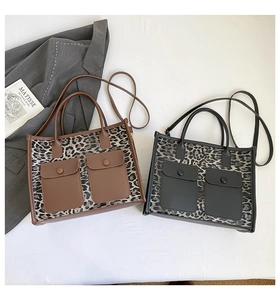 Flat lay detail of leopard print tote bags with solid color pockets and shoulder straps