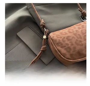 Détail de la texture suédée imprimé léopard et bandoulière en cuir nouée du sac à bandoulière