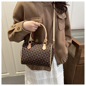 Détail du sac Boston à motif géométrique avec bords rouges et poignées élégantes