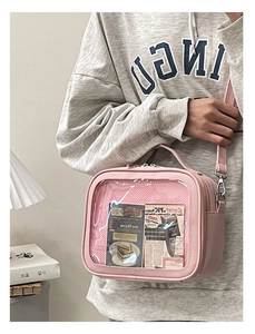 Pink ita-bag with large transparent window and adjustable strap shown on model