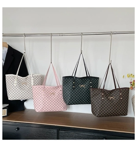 Détail de quatre sacs cabas vintage à monogramme avec boucles de nœud dorées