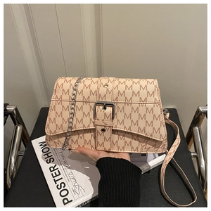 Detail view of pink-brown crossbody bag with M-letter print and gold metal chain strap