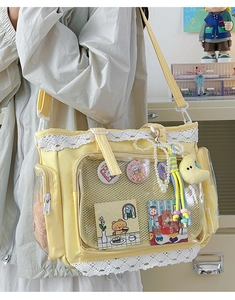 Nahaufnahme einer hellgelben Canvas Ita-Bag mit klarem PVC-Fenster und Spitzenbesatz