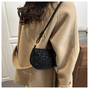 Détail du petit sac bandoulière léopard avec bandoulière nouée sur manteau en laine