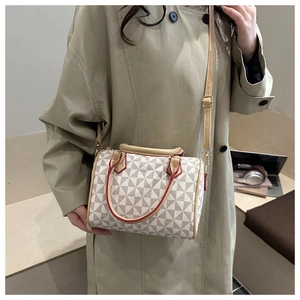 Vue détaillée d'un sac Boston vintage aux motifs géométriques gris sur fond blanc