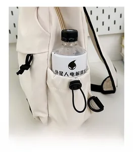 Detail view of the beige sling bag featuring a functional side pocket with adjustable drawstring