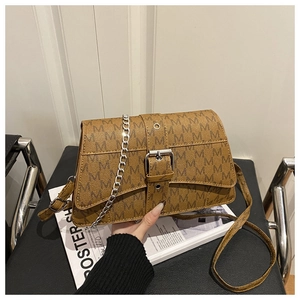Detail of brown vintage crossbody bag with letter M print and silver chain link strap