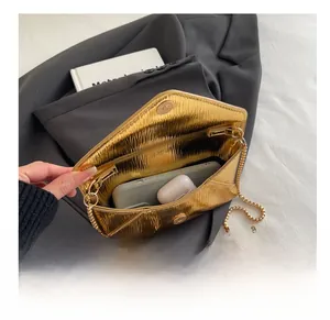 Vue intérieure de la pochette dorée plissée montrant l'espace pour téléphone et écouteurs