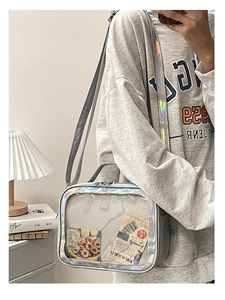 Detail of silver iridescent laser crossbody bag with clear window and rainbow reflection