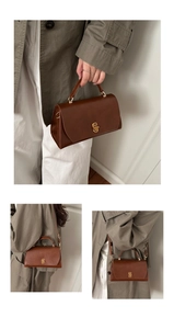 Detail of vintage dark brown leather crossbody bag with a distinctive golden C-lock