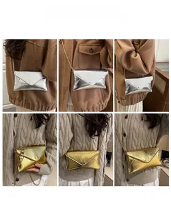 Vue détaillée des sacs enveloppe texturés or et argent avec bandoulières chaînes