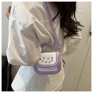 Detail of lavender and white cherry print handbag with golden hooks and slim shoulder strap