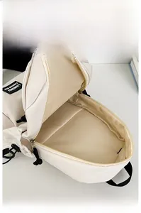Macro view of a cream crossbody bag showing its large interior and nylon texture