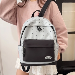 Stylish light grey polka dot backpack with front black pocket for casual student travel