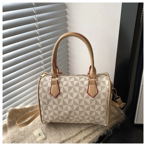 Détail du sac Boston avec motif triangle gris, finitions cuir beige et bordure rouge