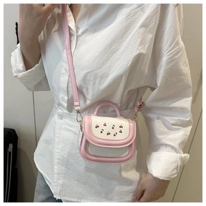 Detail of pink and white crossbody bag with cherry print and adjustable strap