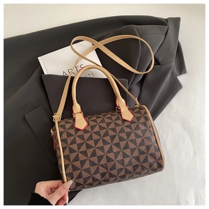 Détail du sac Boston avec imprimés géométriques, poignées beiges et bords peints en rouge