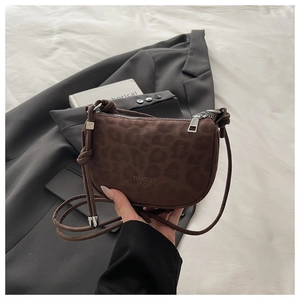 Détail du sac à bandoulière vintage léopard avec sangle nouée et zip argenté