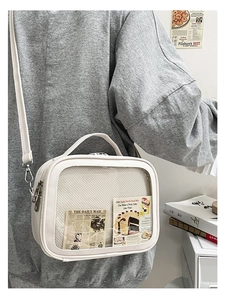 Detail view of white ita bag with transparent display window and adjustable strap