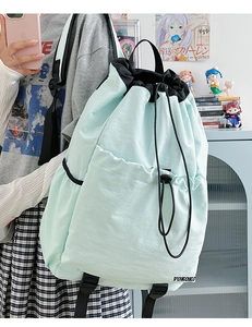 Detail of mint green drawstring backpack with VOKOKO logo and lightweight waterproof fabric