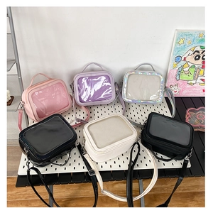 Detailed display of assorted colorful Ita bags with transparent windows and top handles