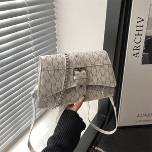 Vintage beige monogram crossbody bag with silver chain strap and metal buckle design
