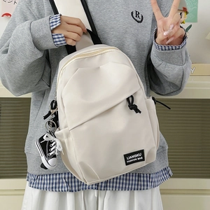 Minimalist beige crossbody sling bag with stylish mini canvas shoe pendant for daily travel