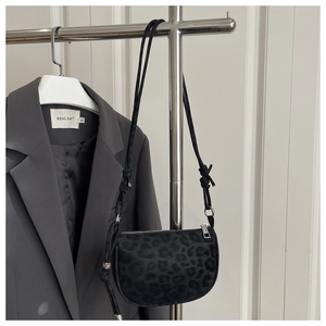 Détail d'un sac bandoulière mat à motif léopard avec fine bandoulière à cordon