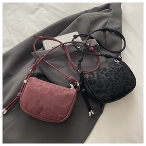 Détail du sac bandoulière vintage à motif léopard avec texture mate et sangle à nœuds