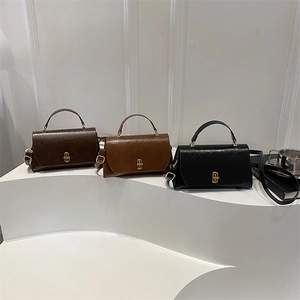 Three minimalist vintage leather crossbody bags in dark brown, tan, and black with gold locks