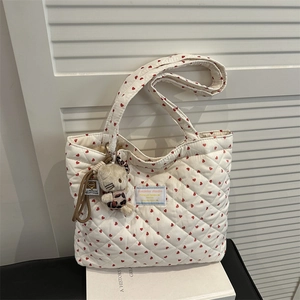 Détail du sac cabas matelassé blanc avec motifs cœurs et porte-clés chat en peluche