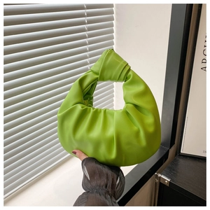 Détail du sac à main vert clair montrant le cuir plissé et la poignée nouée distinctive