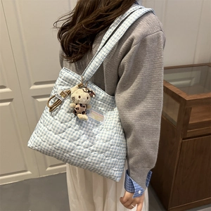 Détail du sac cabas matelassé à carreaux bleu et blanc avec pendentif chat en peluche