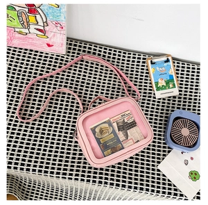 Detail of pink ita bag with a large transparent window and adjustable shoulder strap