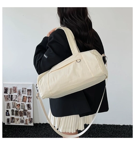 Off-white nylon fitness travel bag shown from back view with adjustable shoulder straps