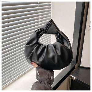 Vue détaillée du sac nuage plissé noir avec une poignée nouée au style minimaliste