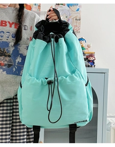 Detail view of mint green drawstring backpack with waterproof nylon fabric and front cord