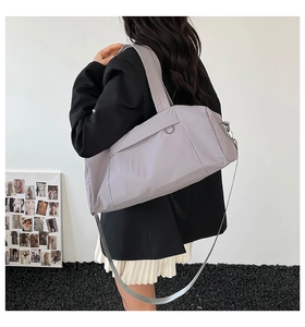 Detailed side view of a large grey nylon travel bag with wide handles and adjustable strap