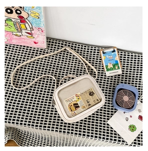 Close-up of white PU crossbody bag with transparent PVC window and interior pattern