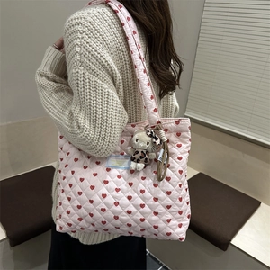 Détail du sac cabas rose surpiqué en cœur avec un pendentif Hello Kitty sur la bandoulière