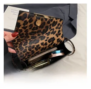 Makroansicht der Leopard-Tasche Innenkapazität mit Handy und Kosmetikartikeln