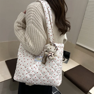 Détail du sac cabas matelassé blanc avec motif cœurs rouges et porte-clés chat en peluche