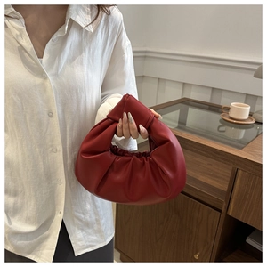 Détail de la poignée nouée et du cuir plissé rouge sur ce sac à main à la mode