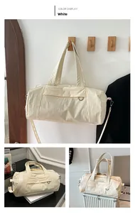 Macro detail of creamy white nylon travel bag with crossbody strap and webbing handles