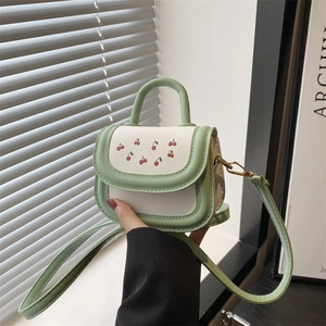 Mini cherry print crossbody bag in green and beige color block design with top handle