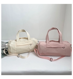 Detail of nylon cylinder gym bags showing smooth water-resistant texture and straps