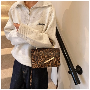 Detailansicht der Schultertasche mit Leopardenmuster, Goldschnalle und Ledergriff