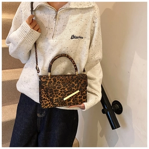 Detail der Leoparden-Schultertasche mit goldener Metallschnalle und fester Struktur